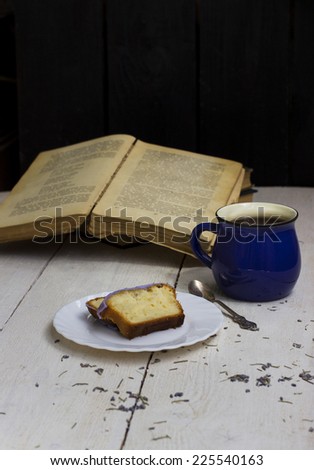 Slice of lavender cake in sugar glaze cake and tea
