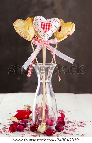 Cookies pops in the form of heart and heart from fabric with buds of roses and ceramic heart