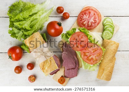 ingredient for sandwich - tomatoes, cheese, cucumber, meat, lettuce on a white background