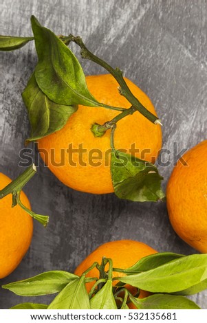 Tangerines with green leaflets on a dark background. Top view.  Food background.