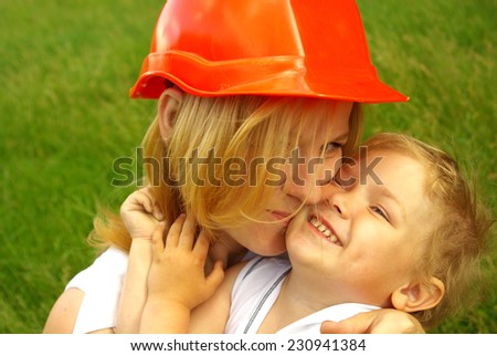 Mom in the construction helmet with love hugging happy daughter