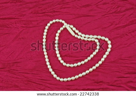 Heart Shape Created with Pearl Necklace on rose color drapery