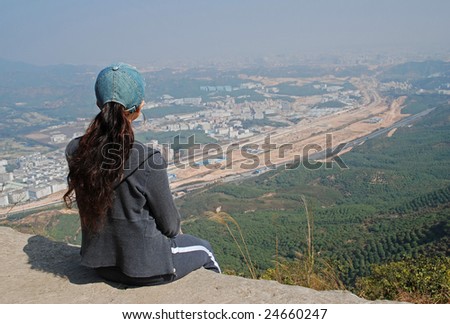Young Woman overlooking and wondering the rapid change in the foggy valley below