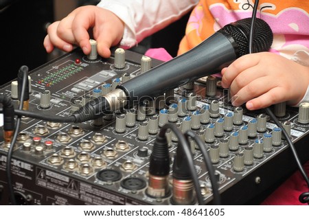 baby hands  sound mike on Audio Mixing Board Sliders. child-disc jockey