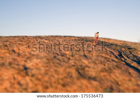 Woman hiking on the red mountain, miniature figure