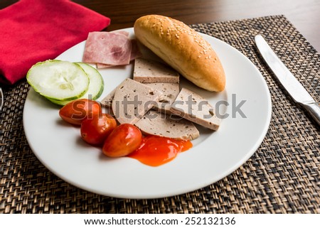 Breakfast with bread, tomatoes, cucumber, pork and cheese