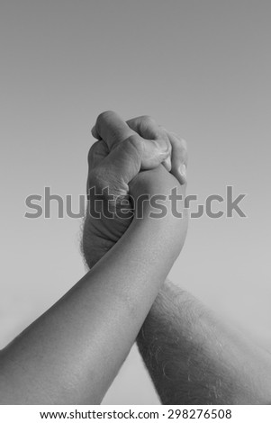 Two hands locked in embrace, isolated in black and white