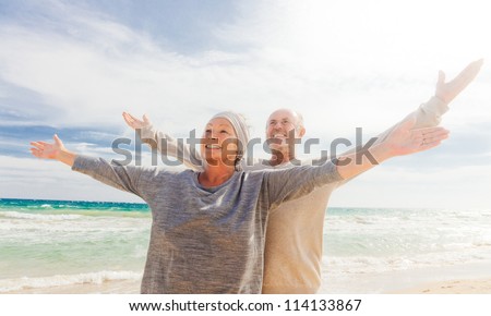 Happy Senior Couple With Outstretched Arms Enjoying Retirement