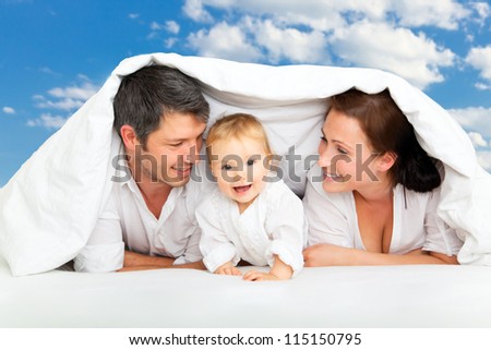 happy family in bed dreaming with clouds for new home