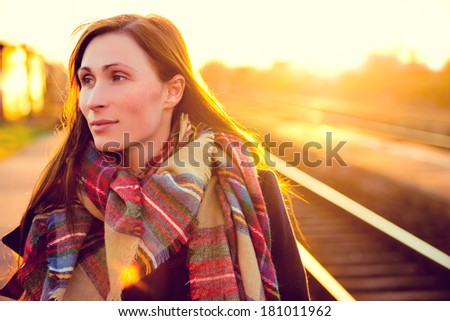 travelling female with sun rays on train station
