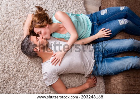 kissing couple couch floor lying down in new home