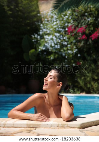 Female in pool smiling with flowers in background