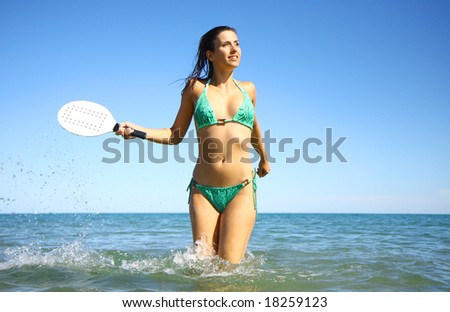 Active woman playing ball in the ocean