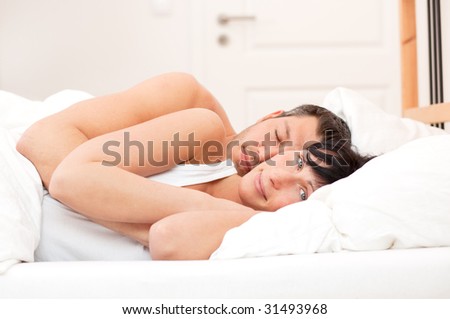 Loving embracing bed lying couple of woman and sleeping man