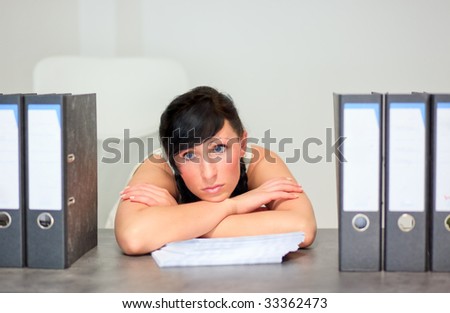 Jobless business woman on desk in office dreaming and posing upset loosing job