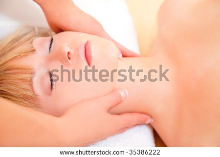 Woman having a spa treatment in beauty center with soften hands on neck