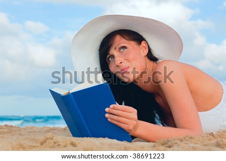 Travel woman reads book on the beach