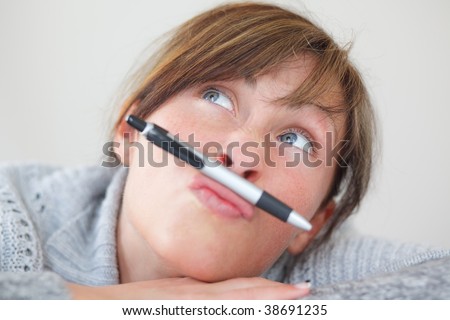Portrait of wondering thinking bored woman with pen