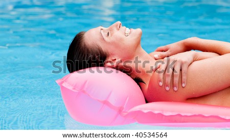 Relaxed woman floating on lilo over blue sea water tanning body