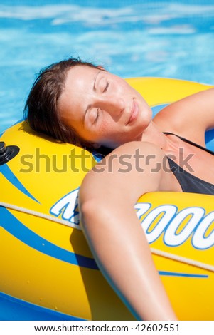 Lilo mattress carefree resting woman floating on blue water in vacation freetime
