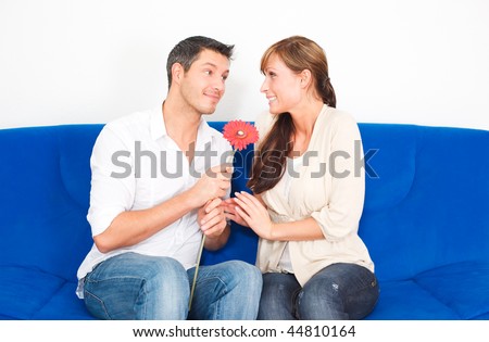 Romantic couple on couch with flower gift on valentine day