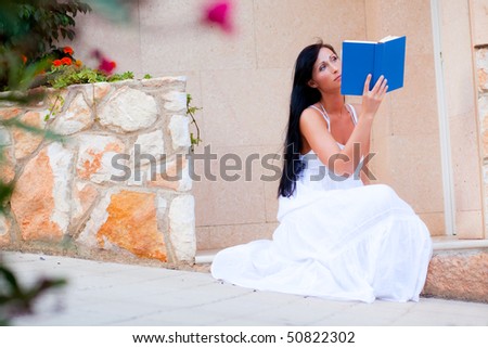 Idyllic scene of book reading woman in mediterrean street