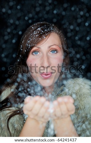 Happy funny female portrait looking snowflakes falling down  in december season