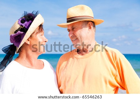 active Relaxed summer vacation senior couple of old man and woman standing on the beach