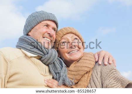 senior couple with blue sky in background having fun in autumn season on the coast in vacation