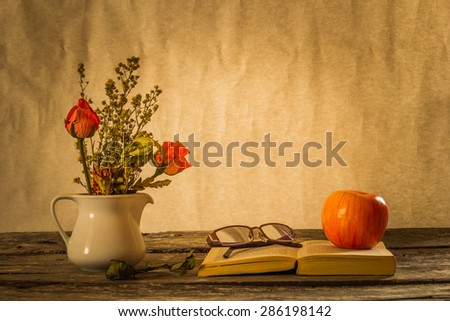 Still Life apple on book and eyeglasses Vases and flower