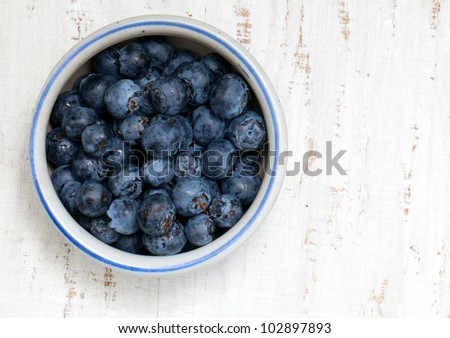 bowl with fresh blueberries on wooden table
