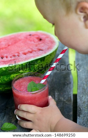 child drinking water melon smoothie