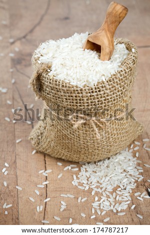 rice in a burlap bag on wooden surface