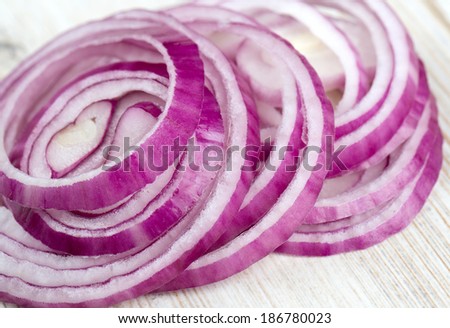 slices of red onions on white wooden surface