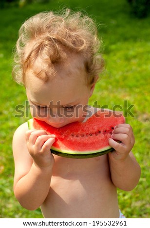cute boy eating water melon outdoors