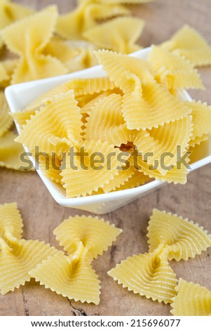 farfalle raw pasta on wooden table