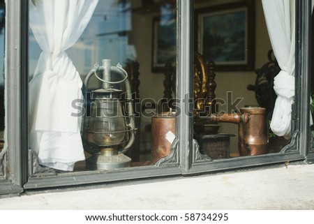 antique oil lamp, coffee mill and kettle at window-sill