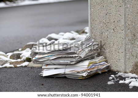 stack of newspapers on a winter street