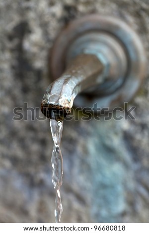 Closeup of water running from outdoor wall faucet