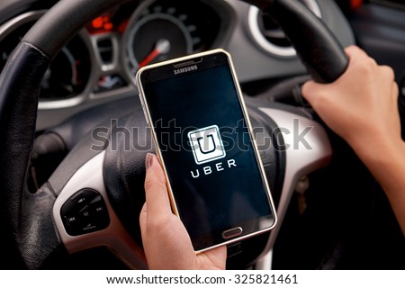 CHIANG MAI,THAILAND - SEP 16,2015 : A woman hand holding Uber app showing on Samsung note 3 in the car,Uber is smartphone app-based transportation network.