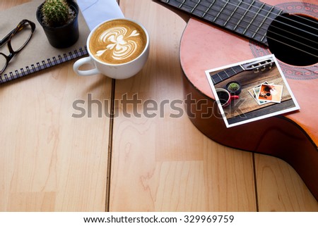 Memories of music travel stuff and cup of coffee latte art on wooden table,vintage tone in photo.