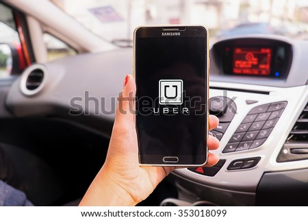 CHIANGMAI,THAILAND - DEC 16,2015 : A woman hand holding Uber app showing on Samsung note 3 in the car,Uber is smartphone app-based transportation network.