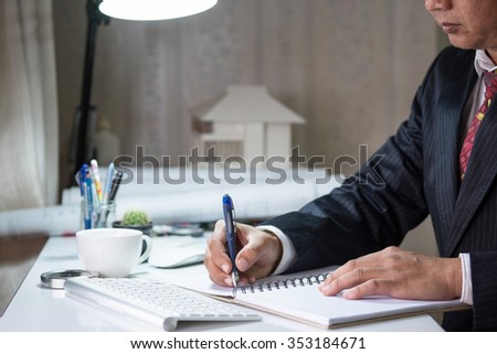 Businessman examines a contract and writing on notebook vintage tone.