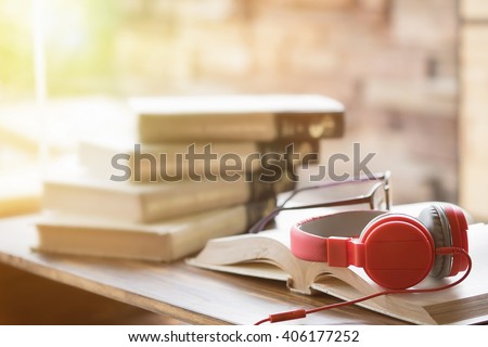 Red headphone on book in cafe or library,morning light.