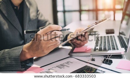Audit concept,Bookkeeper or financial inspector and secretary making report Financial Planning Report in Spreadsheet .Internal revenue Service inspector checking financial document vintage tone.