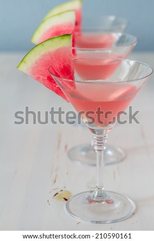 Champagne cocktails with watermelon slice on the side. White wood background