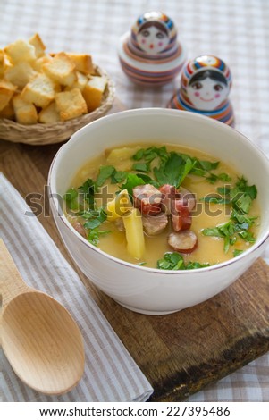 Pea soup, served with dried bread and wood spoon on wood board