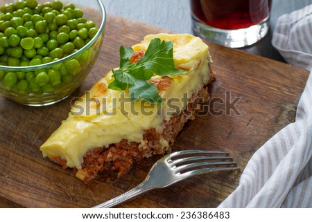 Shepherds pie, served with green peas and dark beer, bite