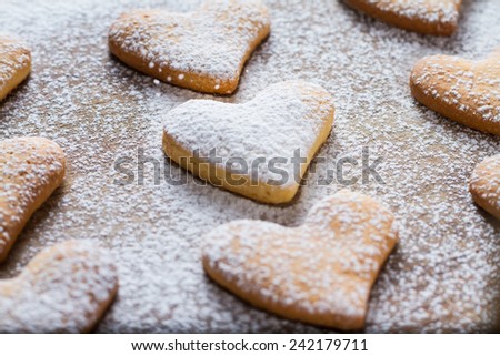 Heart shaped cookies with sugar powder on wood background