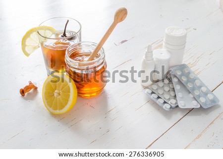 Traditional beverage from dried fruits (uzvar) with honey and lemon Vs pills, drugs, nasal spray, on white wood background